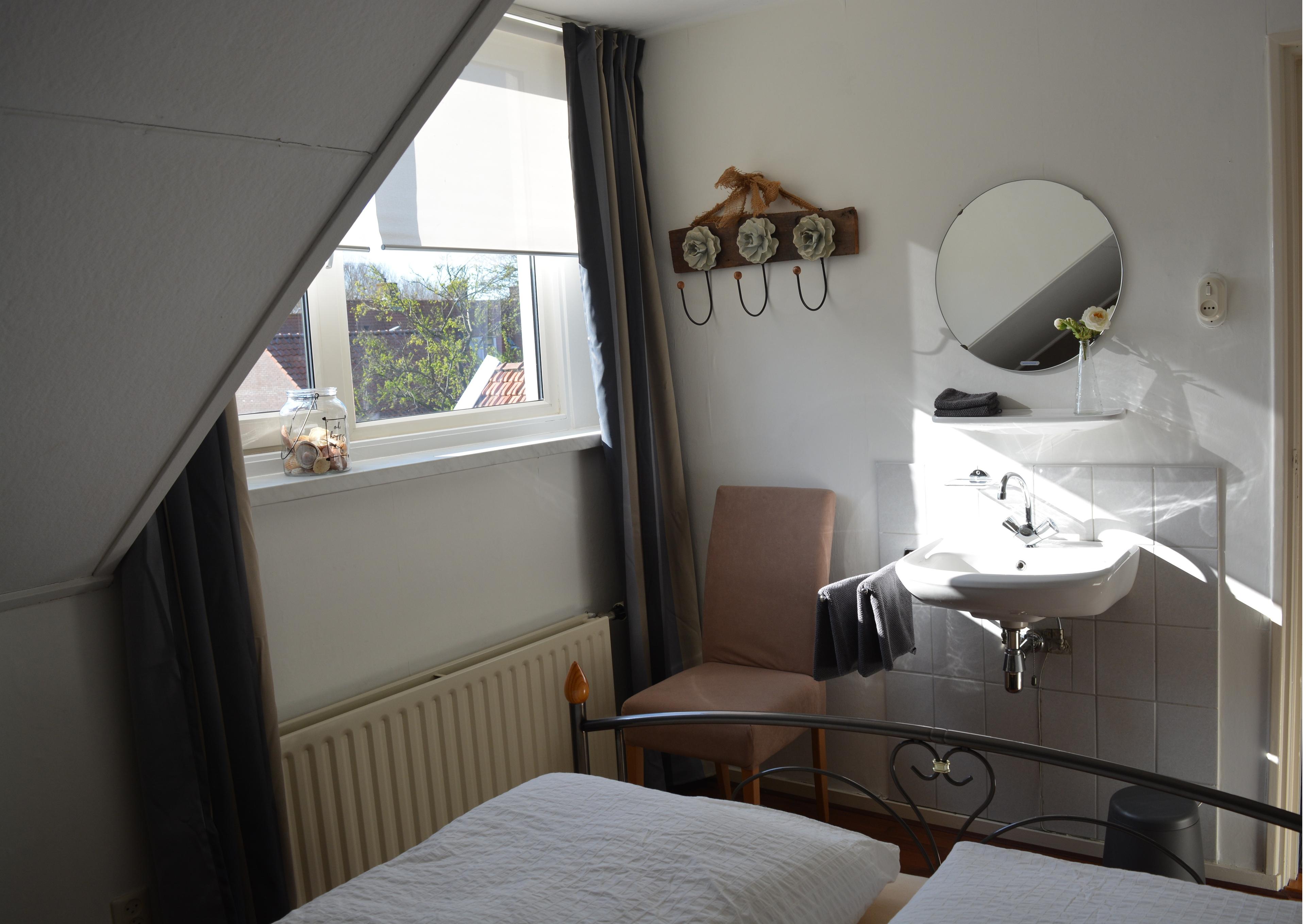 slaapkamer achterzijde voorzien van wastafel met koud en warm water